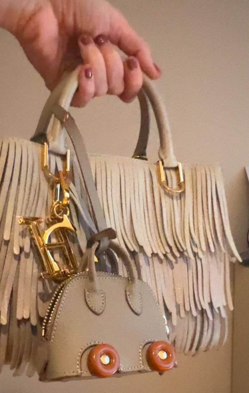 Close-up of the Bodile on Wheels Inspired Bag Charm, featuring a luxurious designer-inspired design with playful wheel details. Functional and stylish, perfect for storing small essentials like AirPods or keys, and adding a touch of elegance to any bag