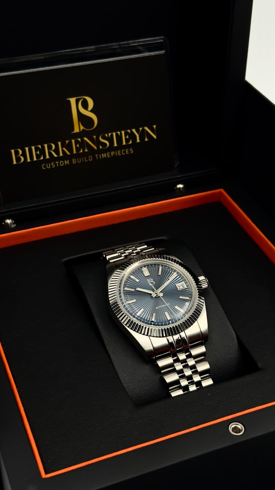 Close-up of the blue dial on the Bierkensteyn Date 38 Blue, featuring luminous hands and a date window