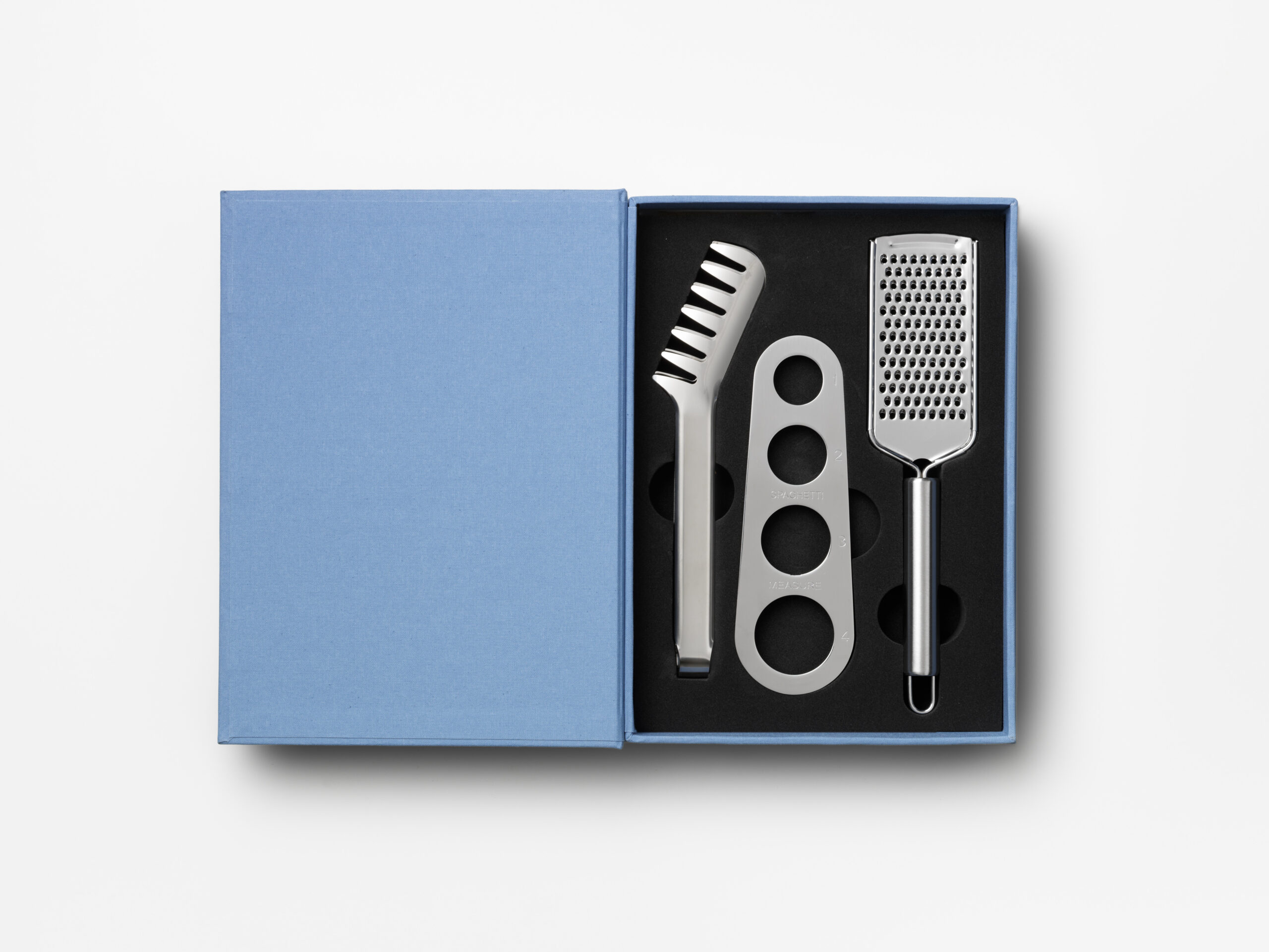 Pasta gift set in bright blue book-style box with stainless steel spaghetti measurer, tongs and grater – luxury gift