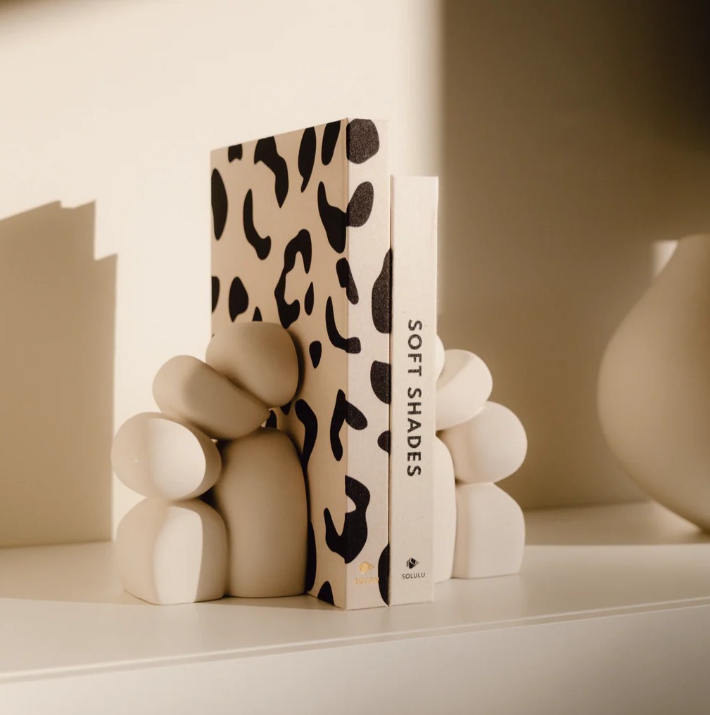 leopard and soft shades combination of coffeetable books on a shelf