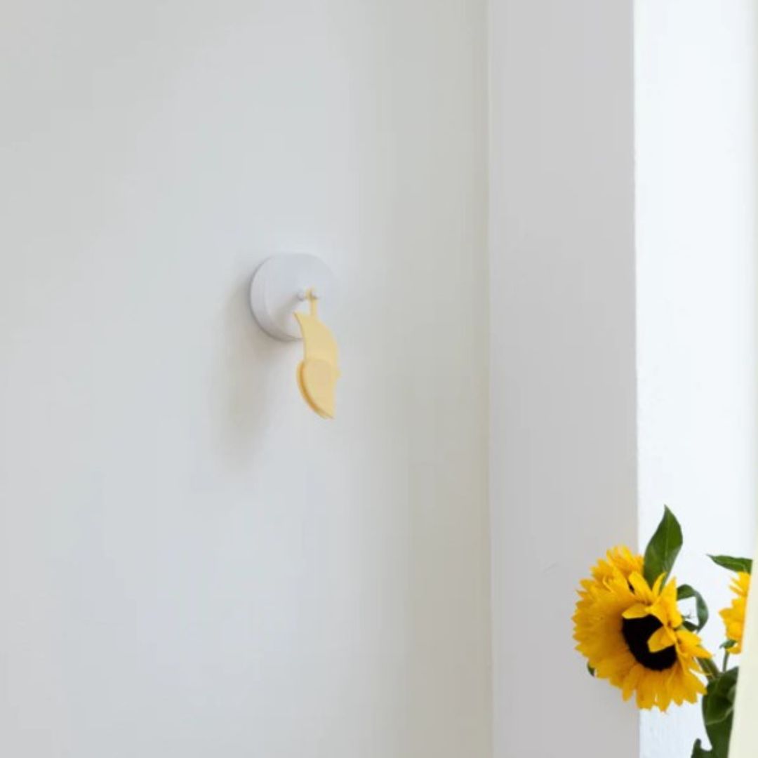 Birdie 2.0 indoor air quality monitor in Dune soft yellow mounted on wall
