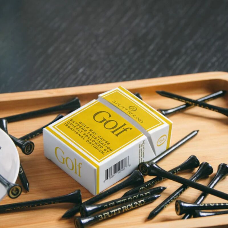 A gold golf tees pack with attitude — compact, playful and made for those who take their game (and style) seriously.